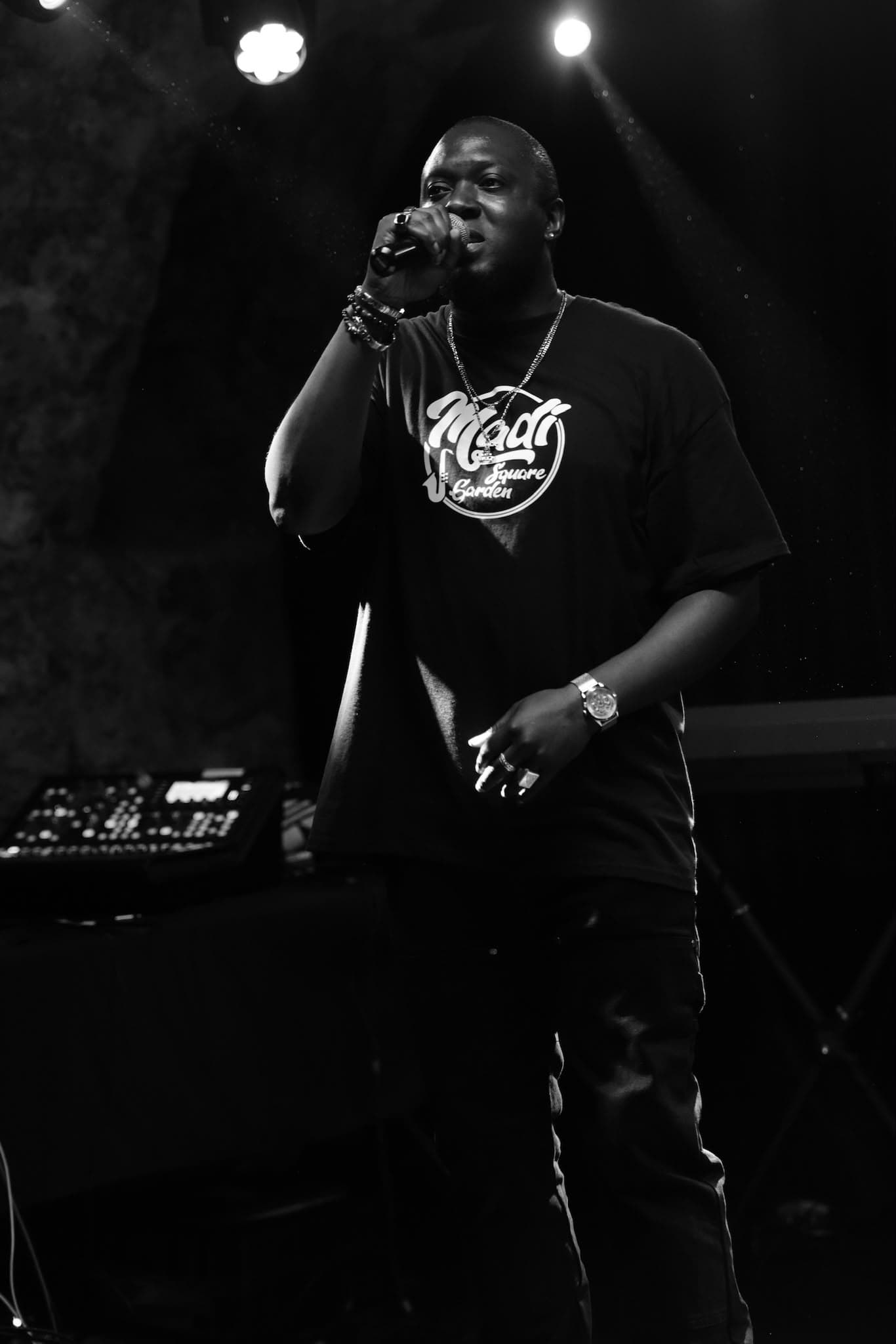 Black Moz au micro sur scène, performance live en noir et blanc